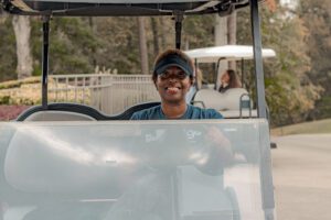 Golfer in cart, Tee IT Up for TechBridge 2021